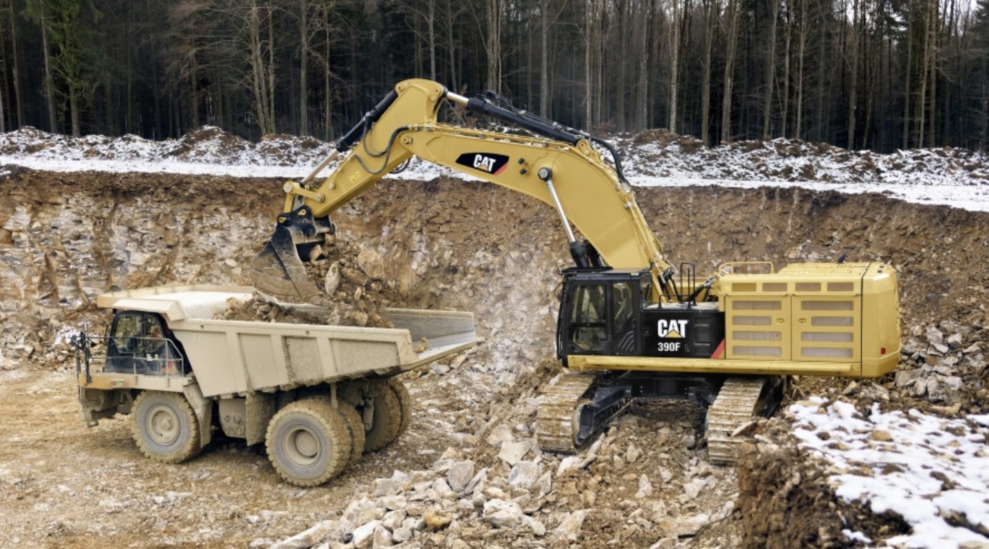 Excavator loading dirt and gravel on truck